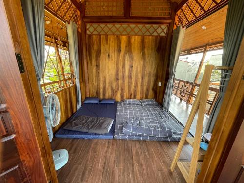 una cama en el interior de una casa pequeña en THE LAND OF LOVE Homestay - Venuestay, en Dak Lak