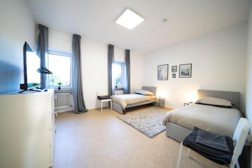a bedroom with two beds and a couch in it at DWK: Monteurwohnung Koblenz in Koblenz