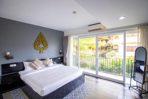 a bedroom with a bed and a large window at 1 BR Serviced Apt In The Heart of Siem Reap in Siem Reap
