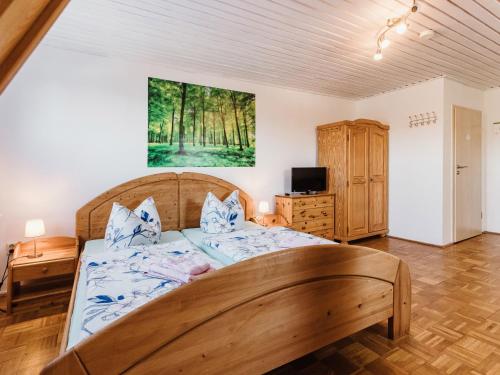 a bedroom with a large wooden bed and a tv at REBENTISCH - HOTEL Ferienwohnungen Restaurant in Hasselfelde