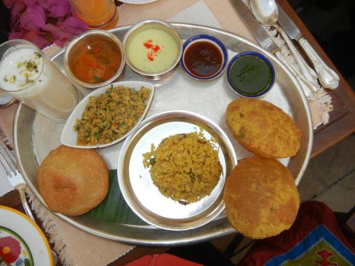 een dienblad gevuld met verschillende soorten voedsel op een tafel bij Hotel Mira Residency- Outer Ring Road, Paschim Vihar in New Delhi