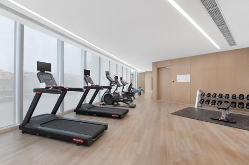 a row of treadmills in a gym with windows at Holiday Inn Quanzhou Donghai by IHG in Quanzhou
