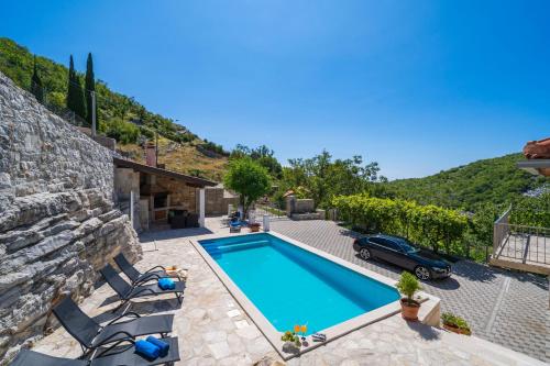 a villa with a swimming pool and a car at Villa Stone House Kuna in Pridvorje