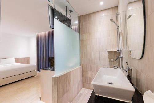 a bathroom with a sink and a shower and a bed at Sukhothai Residence Ruam Ruedi in Bangkok