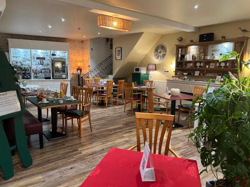 un restaurante con mesas y sillas en una habitación en Le Crist'Al Hôtel de charme en bord de mer, en Saint-Georges-de-Didonne