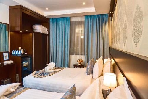 a hotel room with two beds and a teddy bear on top at Selat Al Bait Hotel in Makkah
