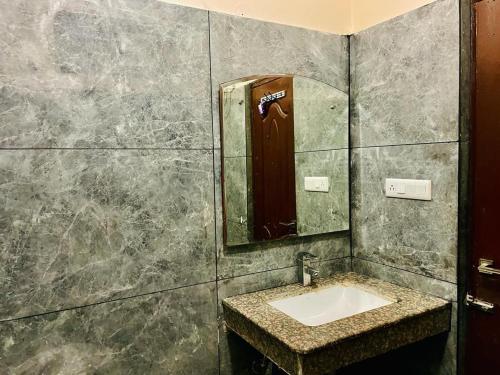 a bathroom with a sink and a mirror at Hotel Suryadev in Pālampur