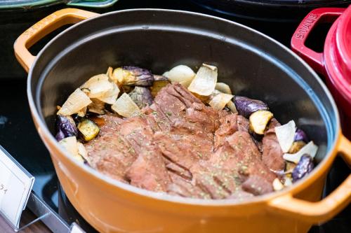 a pot filled with meat and vegetables on a stove at Shibuya Excel Hotel Tokyu in Tokyo