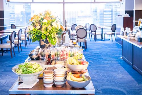 a buffet line with bowls of food on a table at Shibuya Excel Hotel Tokyu in Tokyo