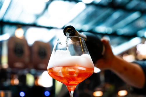 a person pouring a bottle of wine into a wine glass at Porta Cité in Maasmechelen
