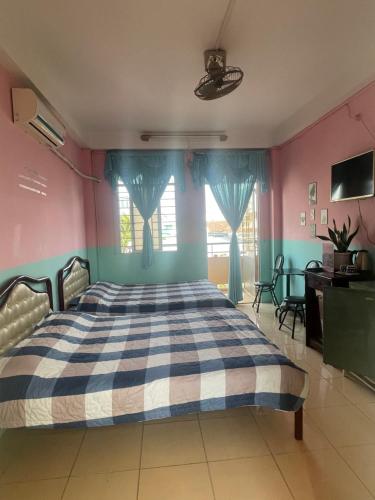 een slaapkamer met een bed met blauwe en roze muren bij Huỳnh Hương Guesthouse in Ha Tien