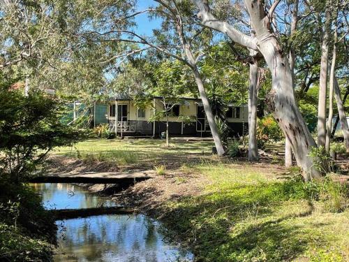 a house with a pond in front of it at Cosy house among the trees in Pemberton