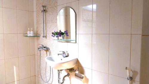 a white bathroom with a sink and a mirror at Surokarsan 9 House Yogyakarta in Yogyakarta