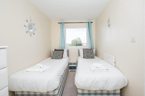 2 aparte bedden in een kamer met een raam bij Seaside Retreat Norfolk in Bacton