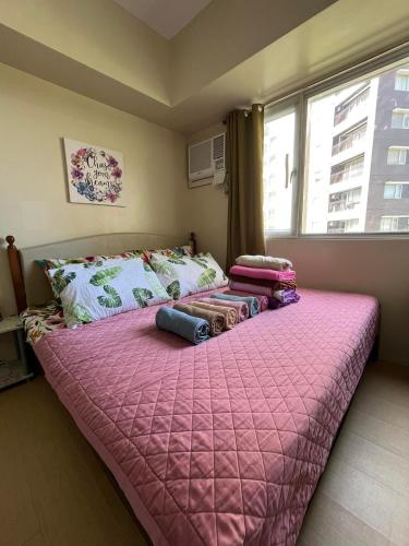 a large pink bed in a room with a window at Avida Atria Tower 1 Studio Type Condominium in Iloilo City