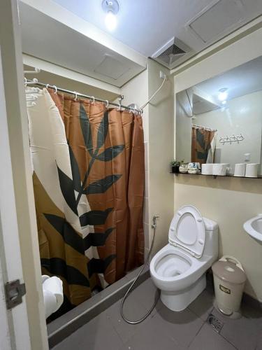 a bathroom with a toilet and a shower curtain at Avida Atria Tower 1 Studio Type Condominium in Iloilo City