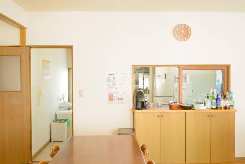 a kitchen with a wooden table and a counter at TESHIKAGA HOSTEL MISATO in Teshikaga