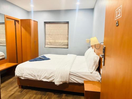 niewielka sypialnia z łóżkiem i oknem w obiekcie Flora hotel w mieście Dźodhpur