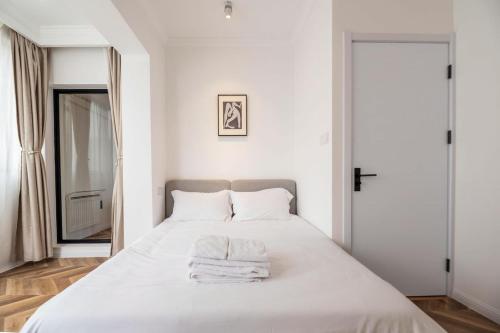 um quarto com uma cama branca e toalhas em Shanghai Hills & Serendipity Bnb em Xangai