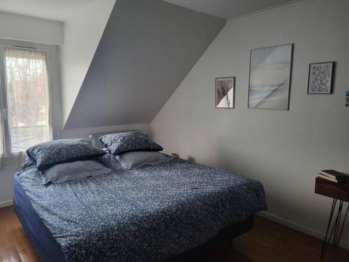 een slaapkamer met een bed met 2 kussens erop bij Maison indépendante avec jardin, ville JO 2024 in Vaires-sur-Marne