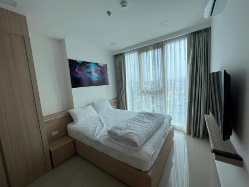 ein Schlafzimmer mit einem Bett und einem großen Fenster in der Unterkunft 秘狗公寓City garden in Pattaya South