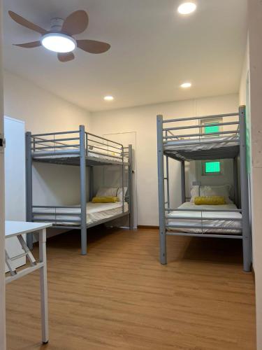 two bunk beds in a room with a ceiling fan at Duke Living in Singapore