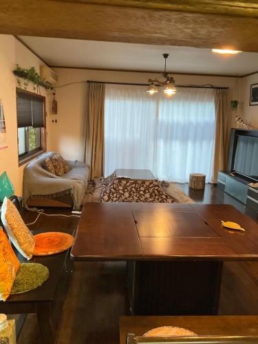 a living room with a couch and a tv at Guesthouse Yui in Hongu