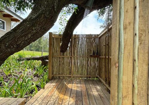 a wooden deck with a fence and a tree at Oakhurst Farm Cottages in Wilderness