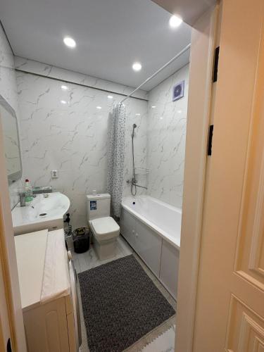 ein Badezimmer mit einer Badewanne, einem WC und einem Waschbecken in der Unterkunft Уметалиева in Bischkek