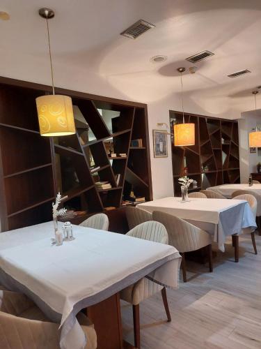 a restaurant with two tables and chairs and shelves at Hotel Pahuljica in Vlasic