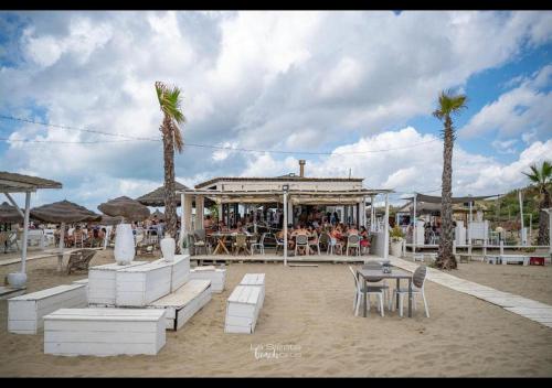 a group of people sitting at a restaurant on the beach at Principi di Piemonte con Piscina in Tirrenia