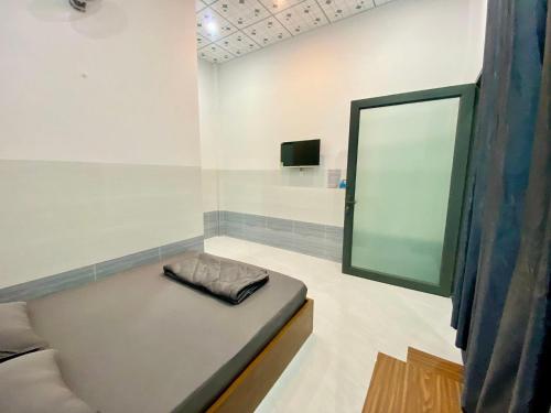 Zimmer mit einem Bett, einem Spiegel und einem TV. in der Unterkunft Motel như ngọc 