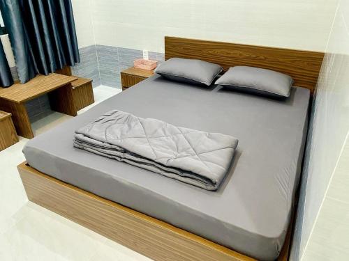 ein großes Bett mit weißer Bettwäsche und Kissen darauf in der Unterkunft Motel như ngọc 
