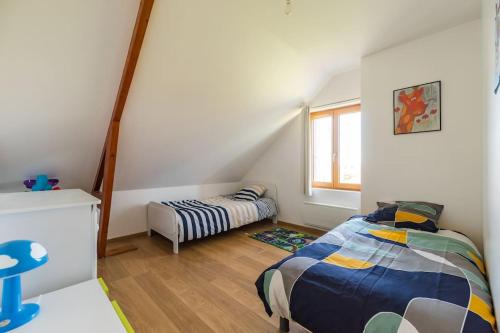 een kleine slaapkamer met 2 bedden en een raam bij La maison d'Alphonse : Plouha, proche de la plage in Plouha