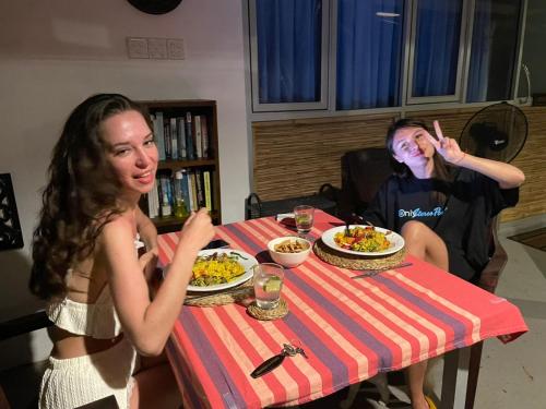 two women sitting at a table with plates of food at Kenno's Korner in Weligama