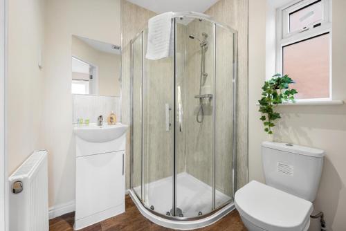 a bathroom with a shower and a toilet and a sink at 4BR Contractor House in Birmingham w/Parking in West Bromwich