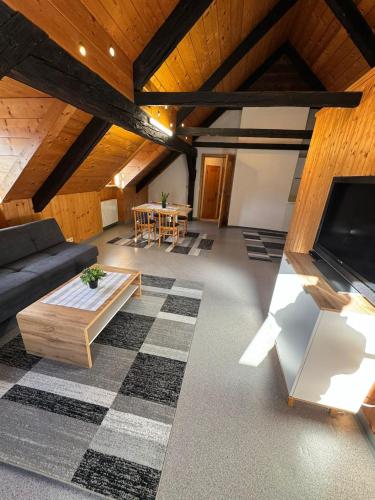 Ático con sala de estar con sofá y TV en Haus-Ennstal, en Öblarn