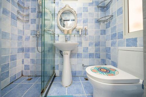 Baño de azulejos azules con aseo y espejo en Shanghai Hills & Well-time Memphis B&B en Shanghái