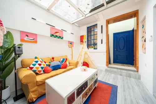 een woonkamer met een gele bank en een blauwe deur bij Shanghai Hills & Well-time Memphis B&B in Shanghai