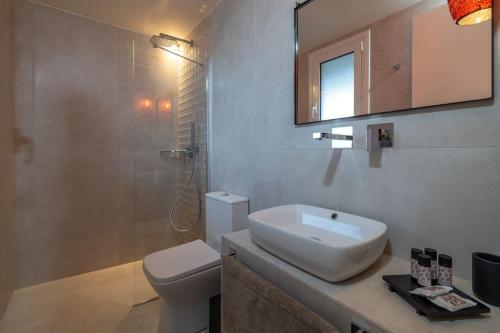 La salle de bains est pourvue d'un lavabo, de toilettes et d'une douche. dans l'établissement THALASSA VIEW RESIDENCE, à Argostóli