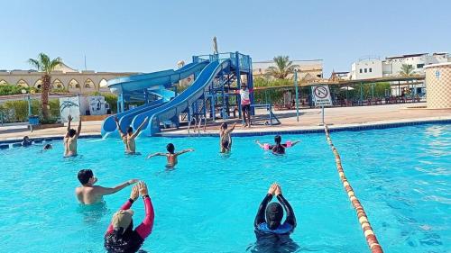 un grupo de personas en el agua en una piscina en Sharm Cliff Hotel en Sharm El Sheikh