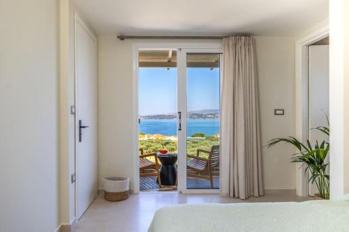 a bedroom with a view of the ocean from a balcony at THALASSA VIEW RESIDENCE in Argostoli