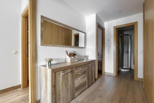 y baño con tocador de madera y espejo. en Apartamento Rural Sierra Guadarrama, en Guadarrama