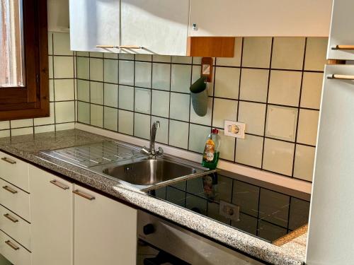 - une cuisine avec un évier et un comptoir dans l'établissement Casa vacanze Valledoria Q8732, à Valledoria