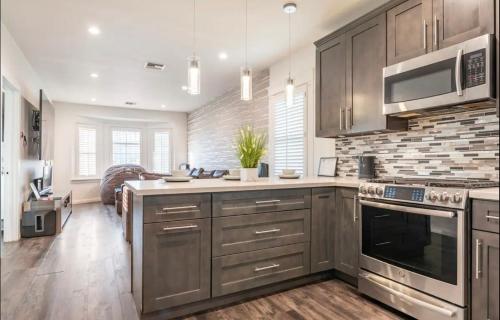 a kitchen with stainless steel appliances and wooden cabinets at Gorgeous DTLA w/ View + Hot Tub! in Los Angeles