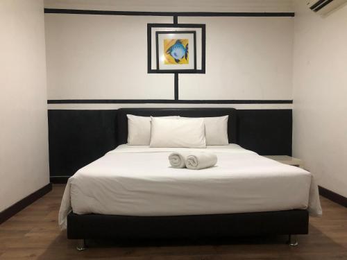 a bedroom with a bed with two towels on it at Ridel Sunset Hotel in Kota Bharu