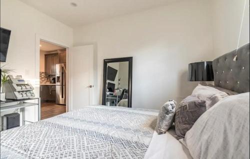 um quarto branco com uma cama e um espelho em Gorgeous DTLA w/ View + Hot Tub! em Los Angeles