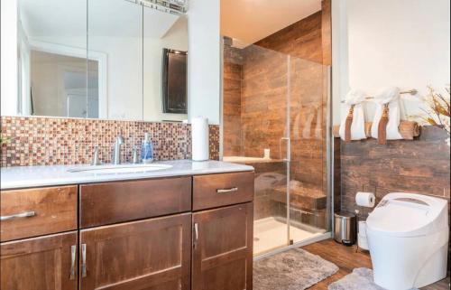 uma casa de banho com um chuveiro, um WC e um lavatório. em Gorgeous DTLA w/ View + Hot Tub! em Los Angeles