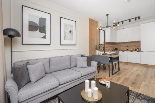 a living room with a couch and a table at Beach Apartments Perłowa Przystań Sztormowa by Noclegi Renters in Sianozety