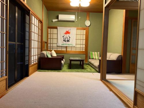 uma sala de estar com um sofá e uma mesa em ゲストハウス Rei em Hongu